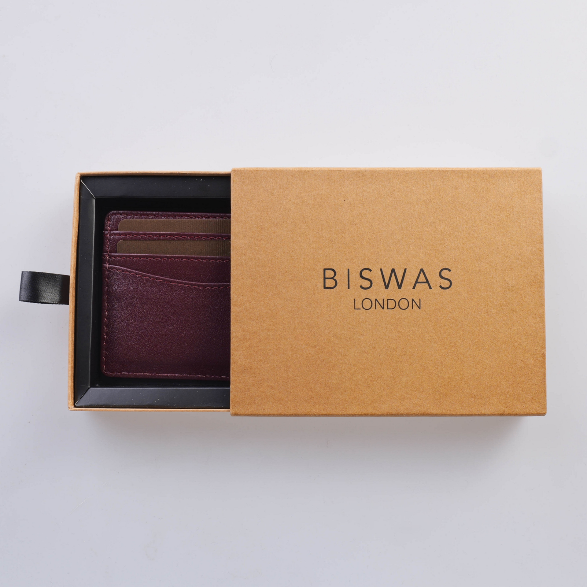 The Diplomat cardholder resting beside its rigid BISWAS LONDON drawer box