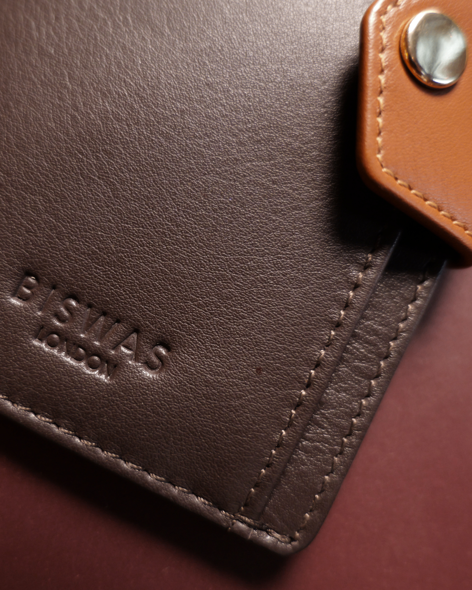 The Diplomat card holder in Oxblood, held in hand